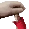 a man in a red hoodie is being punched by a large hand .