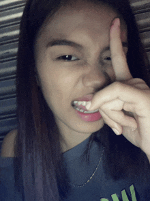 a woman making a funny face with her finger on her face