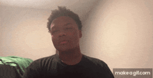 a young man in a black shirt is making a funny face .