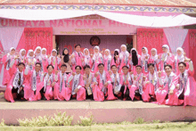 a group of people posing for a picture in front of a banner that says umbaya national high school