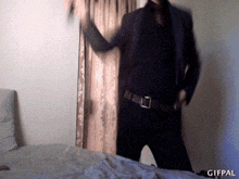 a man in a suit and tie is dancing in a room with a gifpal watermark