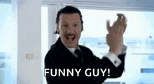 a man in a suit and tie is making a funny guy gesture while wearing a headset .