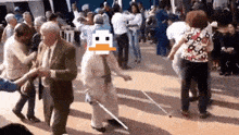 an elderly woman with a cane is dancing in a crowd with a pixelated duck in the background