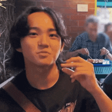 a man wearing a black shirt that says 5w