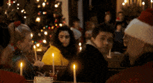 a group of people are sitting in a church with candles lit