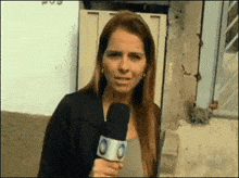a woman is holding a microphone with the letter o on the bottom