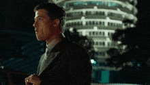 a man in a suit and tie stands in front of a building