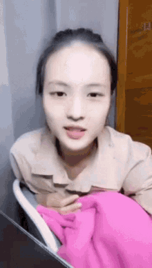 a woman sitting in a chair with a pink blanket