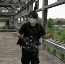 a man wearing a mask is carrying a camera .