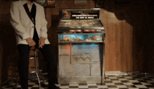 a man sitting in front of a machine that says tap