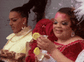 a woman in a red dress is holding a martini glass