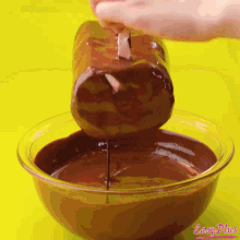 a person pouring chocolate into a glass bowl with easy plus written on the bottom