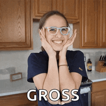 a woman wearing glasses holds her hands to her face and the word gross is above her head