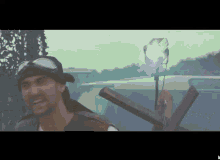 a man wearing goggles and a hat is holding a cross in front of a car