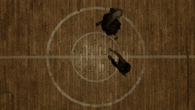 two people standing in a circle on a wood floor