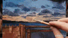 a person is painting a landscape with a brush and the words made in animatica are visible