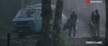 a group of people standing in front of a blue van that says terbaik