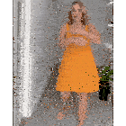 a woman is wearing a yellow dress and dancing in a hallway .