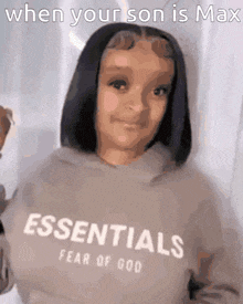a girl wearing a hoodie that says essentials on it