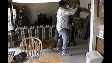 a man and a dog are dancing in a living room .