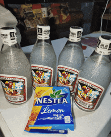 a packet of nestea lemon iced tea sits next to bottles