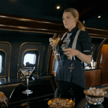 a woman holds a martini in her hand in a room
