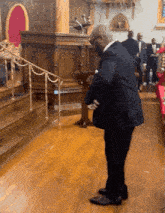 a man in a suit is kneeling down in front of a podium in a church
