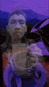 a painting of a man holding a cup of coffee with a mountain in the background