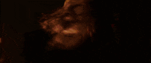 a close up of a woman 's face in a red room .