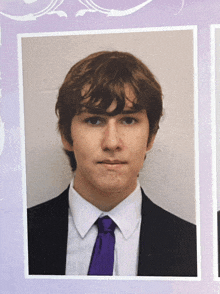a young man in a suit and tie poses for a photo