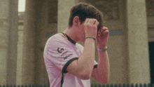 a man wearing a white shirt with a g logo on it