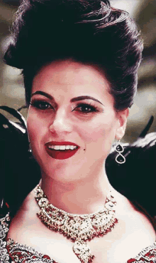 a close up of a woman wearing a necklace and earrings with infinity symbols