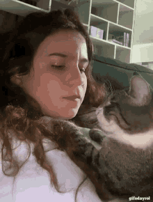 a woman laying on a couch with a cat on her shoulder and the words gifsdayrol on the bottom