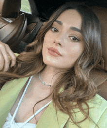 a woman in a green jacket is sitting in the back of a car