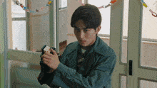 a man in a green jacket is holding a remote control