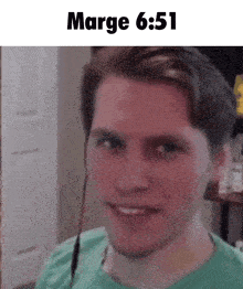 a man in a green shirt is smiling with the time 6:51
