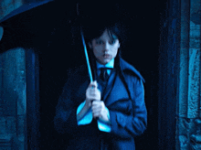 a girl in a trench coat holds an umbrella