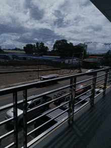 a view of a street from a balcony with cars parked on the side of the road