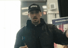 a man wearing a black hat that says hello world