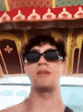 a man wearing sunglasses is making a funny face while standing in front of a coffin .