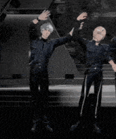 a group of people are standing with their arms up in the air