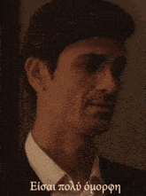 a close up of a man 's face with the words " eisai polo omopon " below him