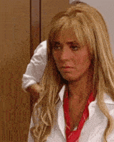 a woman wearing a white shirt and a red tie looks sad