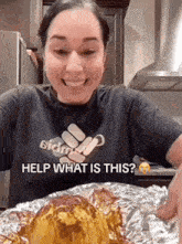 a woman in a black shirt is smiling while holding a piece of foil .