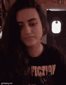 a woman wearing a fiction shirt is eating something
