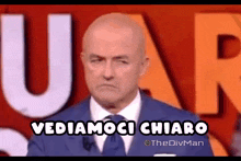 a man in a suit and tie is standing in front of a sign that says vediamoci chiaro