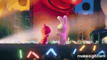 two stuffed animals are standing on a stage in front of a crowd .