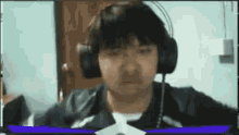 a man wearing headphones is looking at the camera .