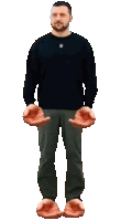 a man wearing a black sweater and grey pants is holding his hands out