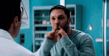a man with a beard looks at himself in the mirror